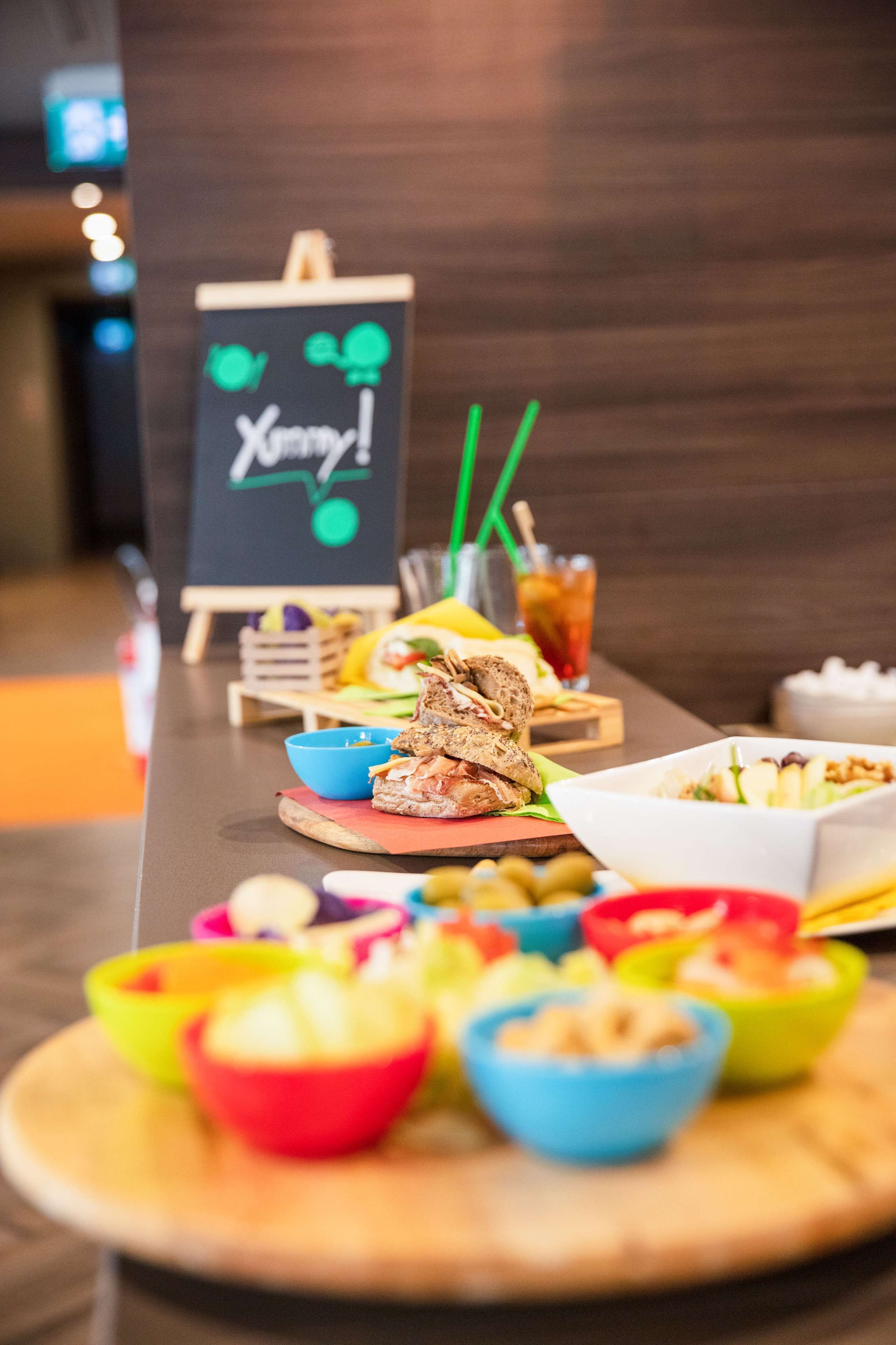 A buffet table with various food items and a chalkboard sign in the background.