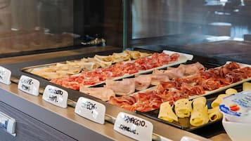Un comptoir de charcuterie proposant une variété de viandes et de fromages, chacun étant clairement étiqueté pour faciliter le choix.
