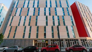 Een hotel met een moderne gevel, grote ramen en een opvallend bord met de tekst "Camparile HOTEL".
