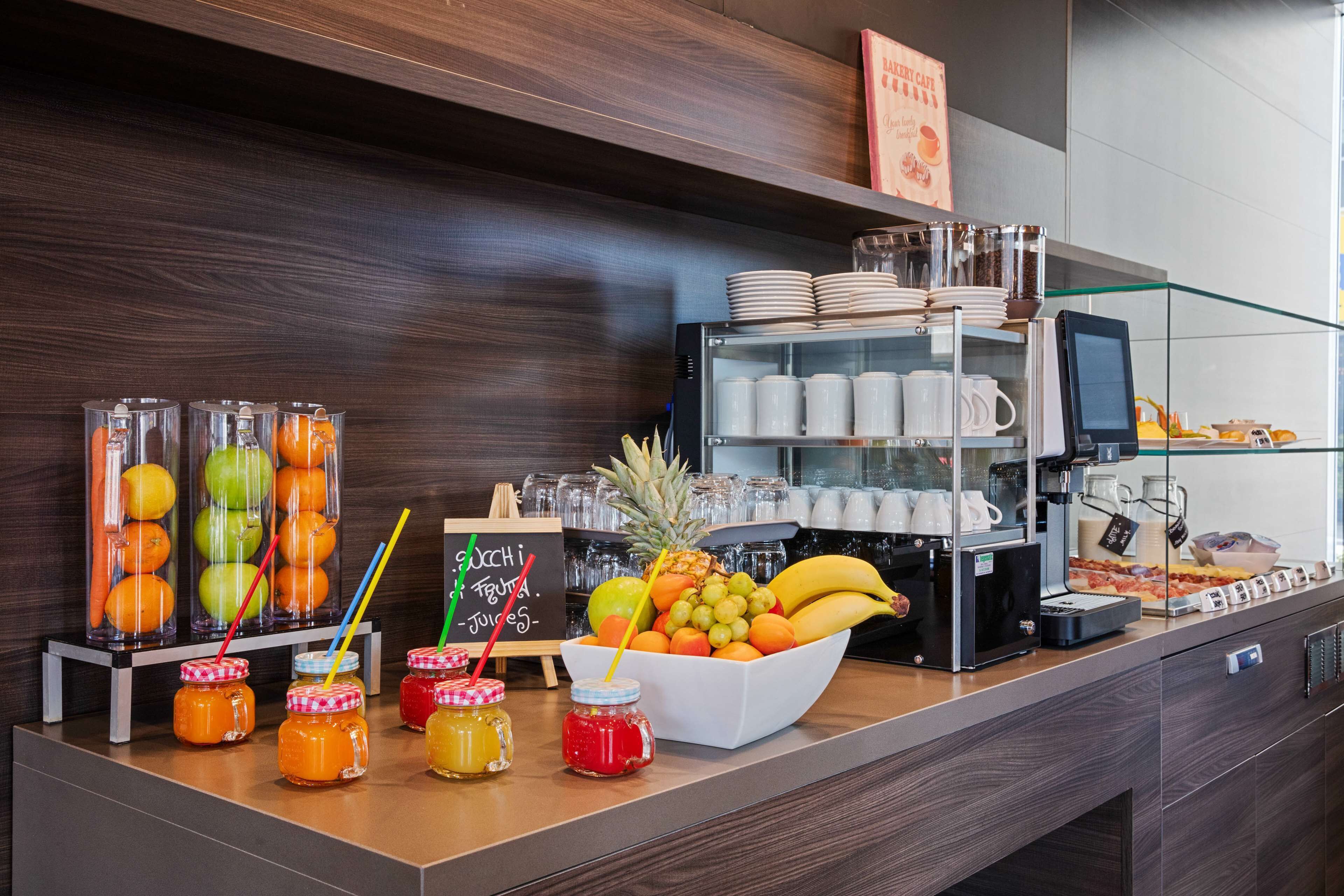 Una colazione a buffet con frutta, condimenti e una macchina per il caffè.