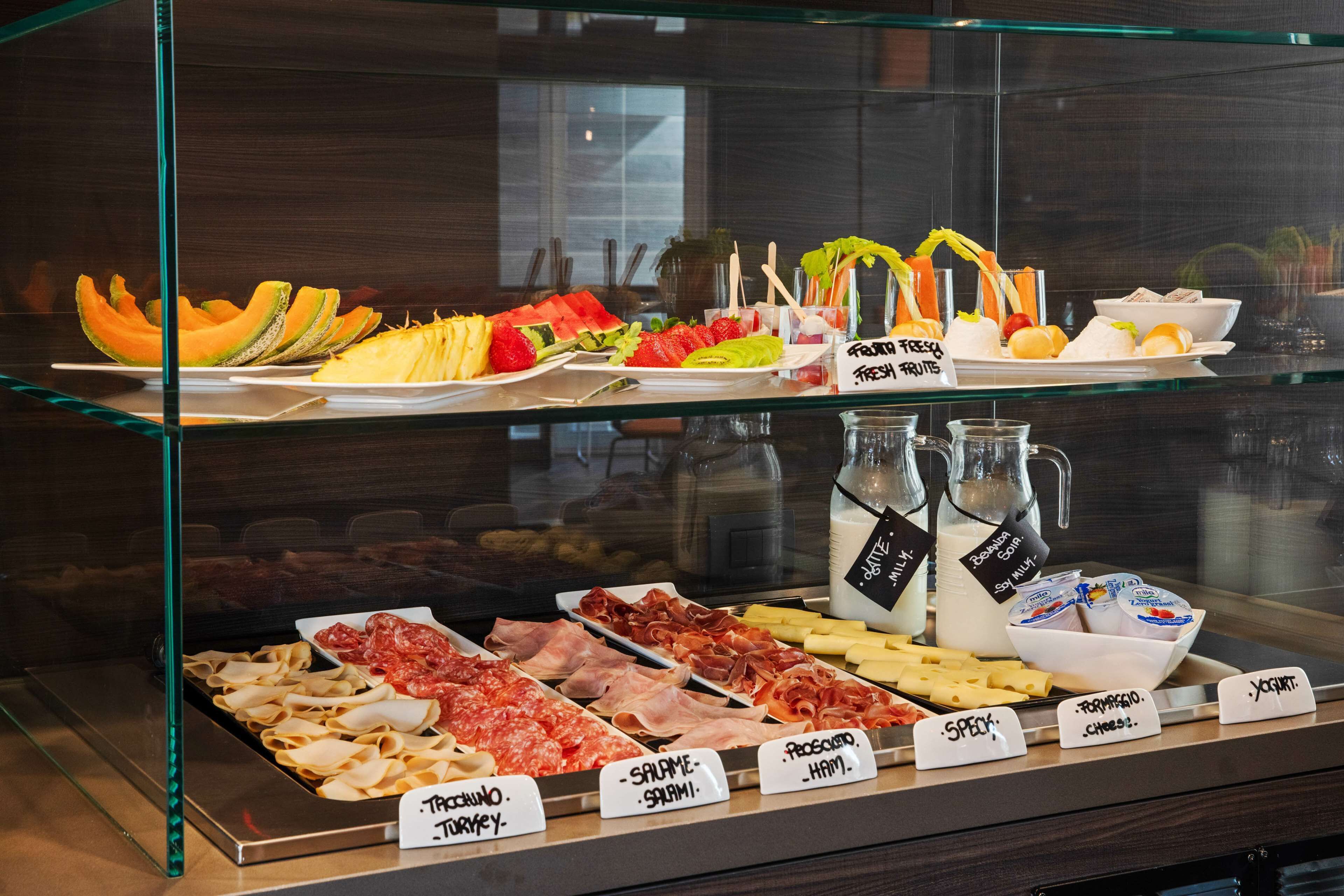 A deli counter with various meats and cheeses, including turkey, salami, ham, and prosciutto.