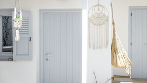 A light blue door with a small sign above it, a macrame wall hanging, and a macrame hammock.