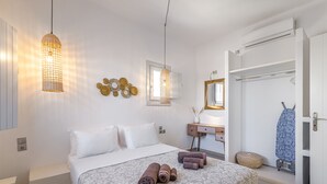 A neatly arranged bedroom with a bed, bedside table, and a mirror.