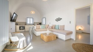 A modern living room with a sofa, a coffee table, and a TV mounted on the wall.