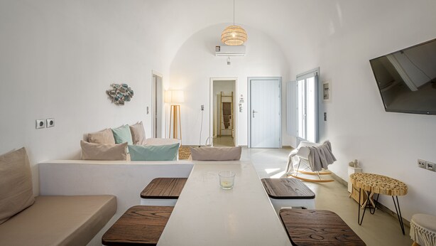 A modern living room with a sofa, a coffee table, and a TV mounted on the wall.