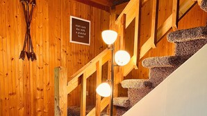 A wooden staircase with a circular seating area containing cushions and a decorative pillow.