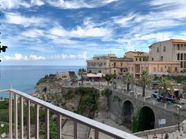 Un pueblo costero con edificios históricos, un puente y vista al mar.