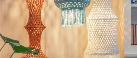Trois lampes suspendues en crochet, ornées de glands de différentes couleurs.
