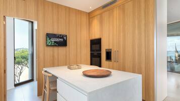 Una cocina moderna con armarios de madera, una isla grande y vistas al exterior.