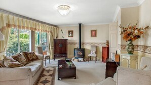 Una sala de estar tradicional con chimenea, un sofá, una mesa de centro y vistas al exterior.