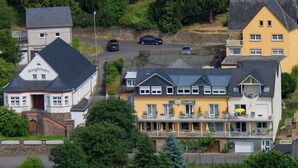A hotel with a prominent balcony, a visible entrance, and a sign indicating the name 'Sängerheim'. - Hotel Weinhaus Moselblick (Burg)