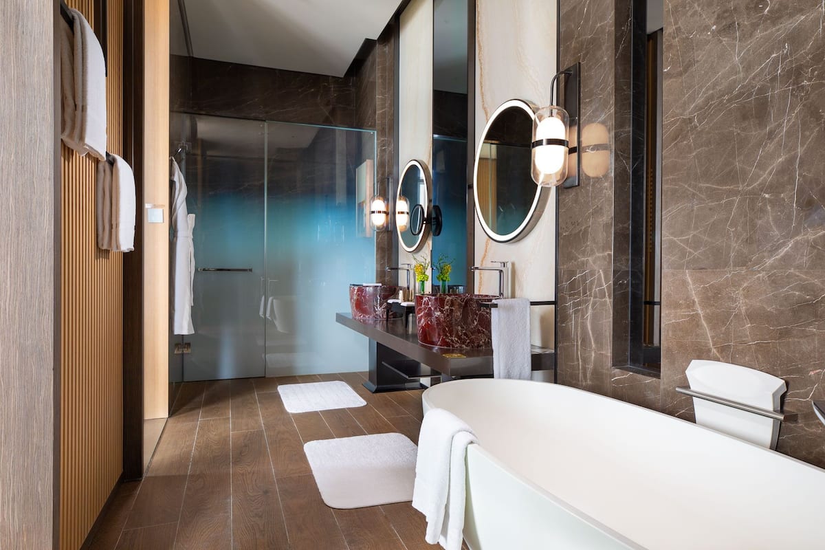 deluxe suite | bathroom | separate bathtub and shower, rainfall showerhead, designer toiletries