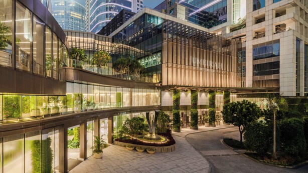 A modern hotel with a central courtyard, glass railings, and greenery. - Jumeirah Guangzhou (Guangzhou)