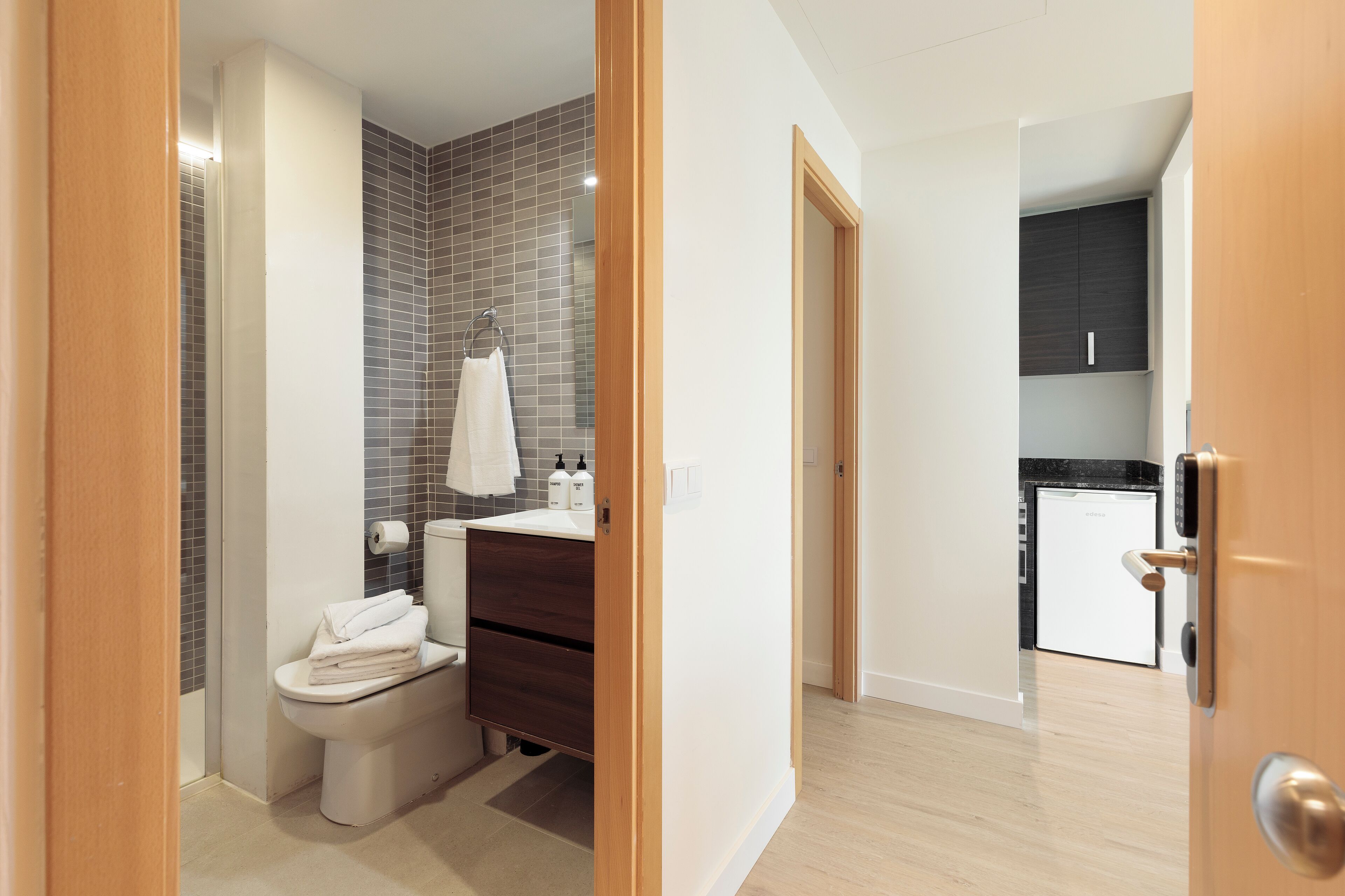 A modern bathroom with a toilet, sink, and towel rack.
