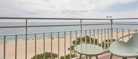 A balcony with a view of a beach and a clear sky.