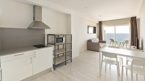 Una cocina moderna con microondas, estufa integrada y extractor de acero inoxidable.