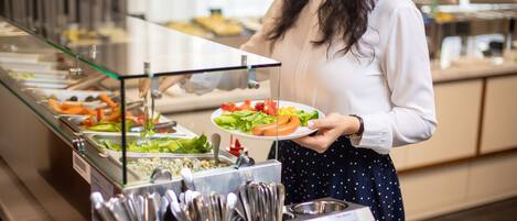 A buffet area with various food items and utensils.