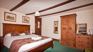 Un dormitorio con cama de madera, cómoda y espejo.