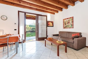 Appartamento, 1 camera da letto, patio | Area soggiorno | TV a schermo piatto