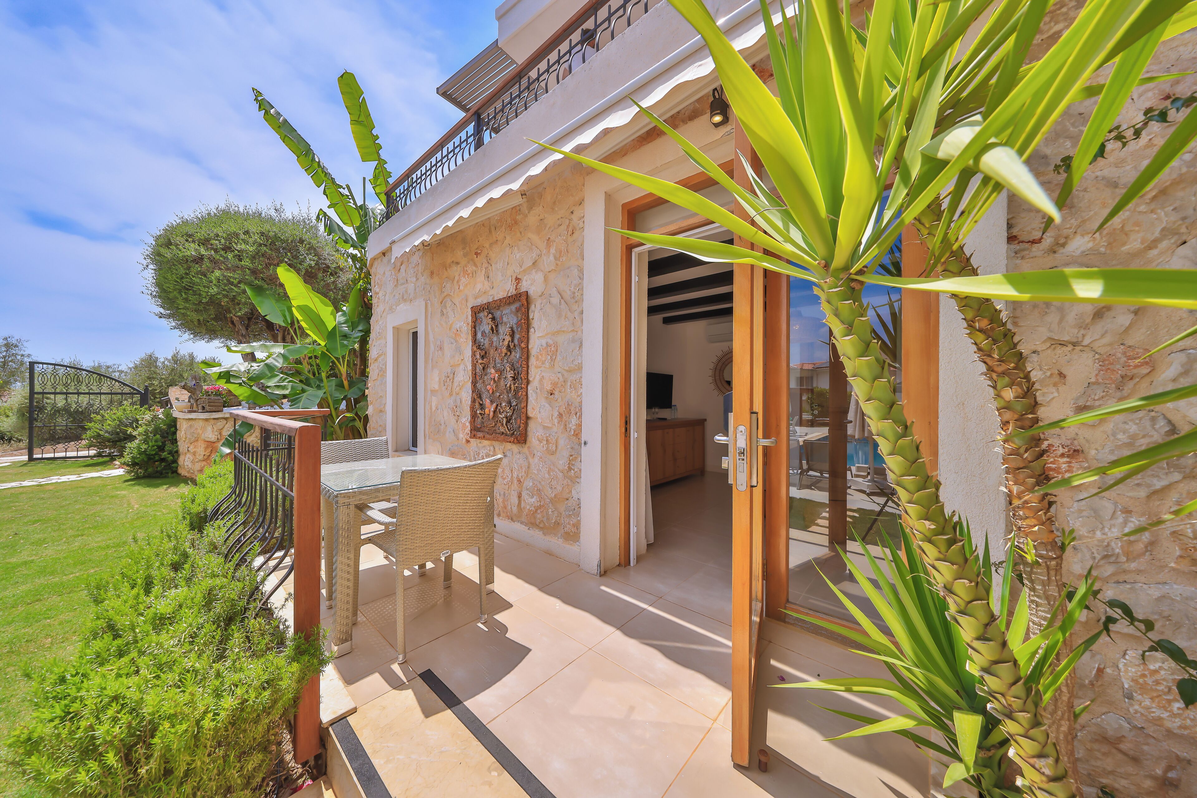 Una casa con un patio, comedor y jardín.