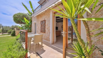 Una casa con un patio, comedor y jardín.