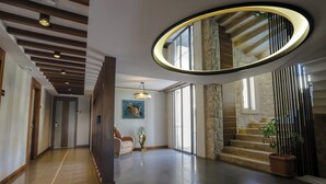 A spacious hallway with a modern staircase, a chandelier, and a potted plant. - Molino Hotel (Kas)
