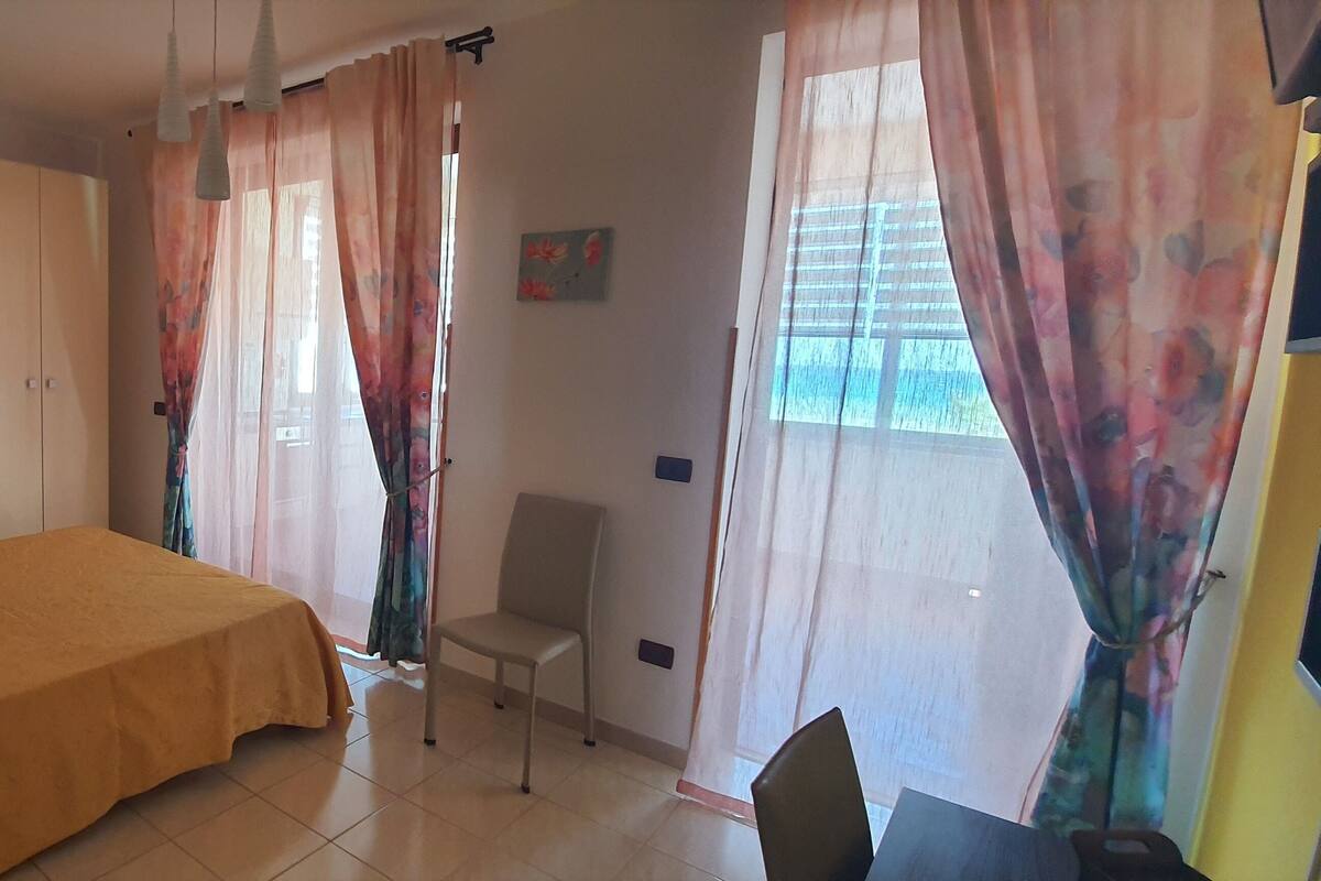 Une chambre à coucher avec un lit, une chaise, un bureau et une armoire.