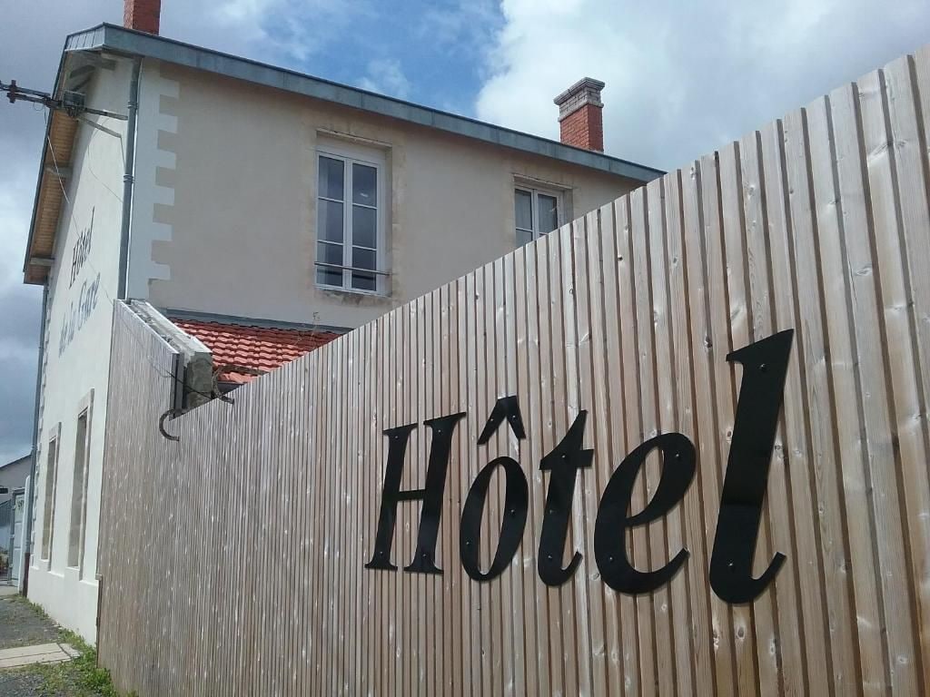Une enseigne d'hôtel avec le mot « Hôtel » sur un mur en métal ondulé.