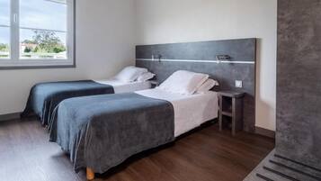 A hotel room with two beds, a window, and a modern design.