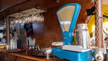 Un macinacaffè vintage con corpo bianco e blu, un contenitore metallico e un imbuto in metallo.