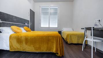 Ein Hotelzimmer mit zwei Betten, einem Schreibtisch und einem Stuhl.