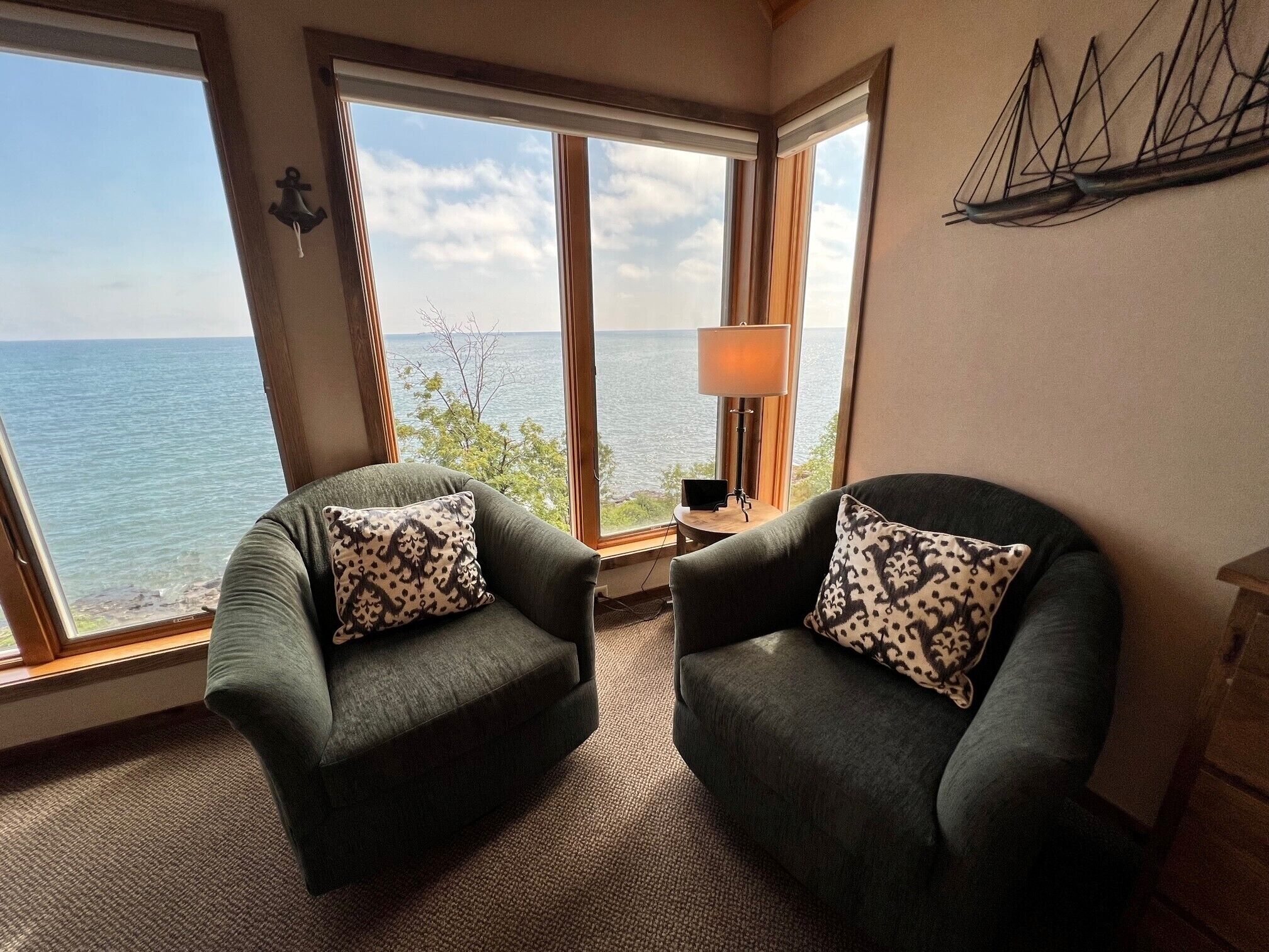 Una habitación con dos sillones mirando hacia una ventana grande con vistas al mar.