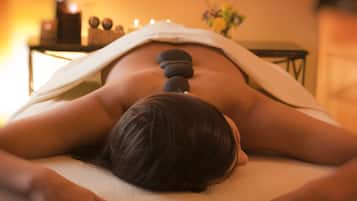 Experience a rejuvenating massage with smooth stones along the spine.