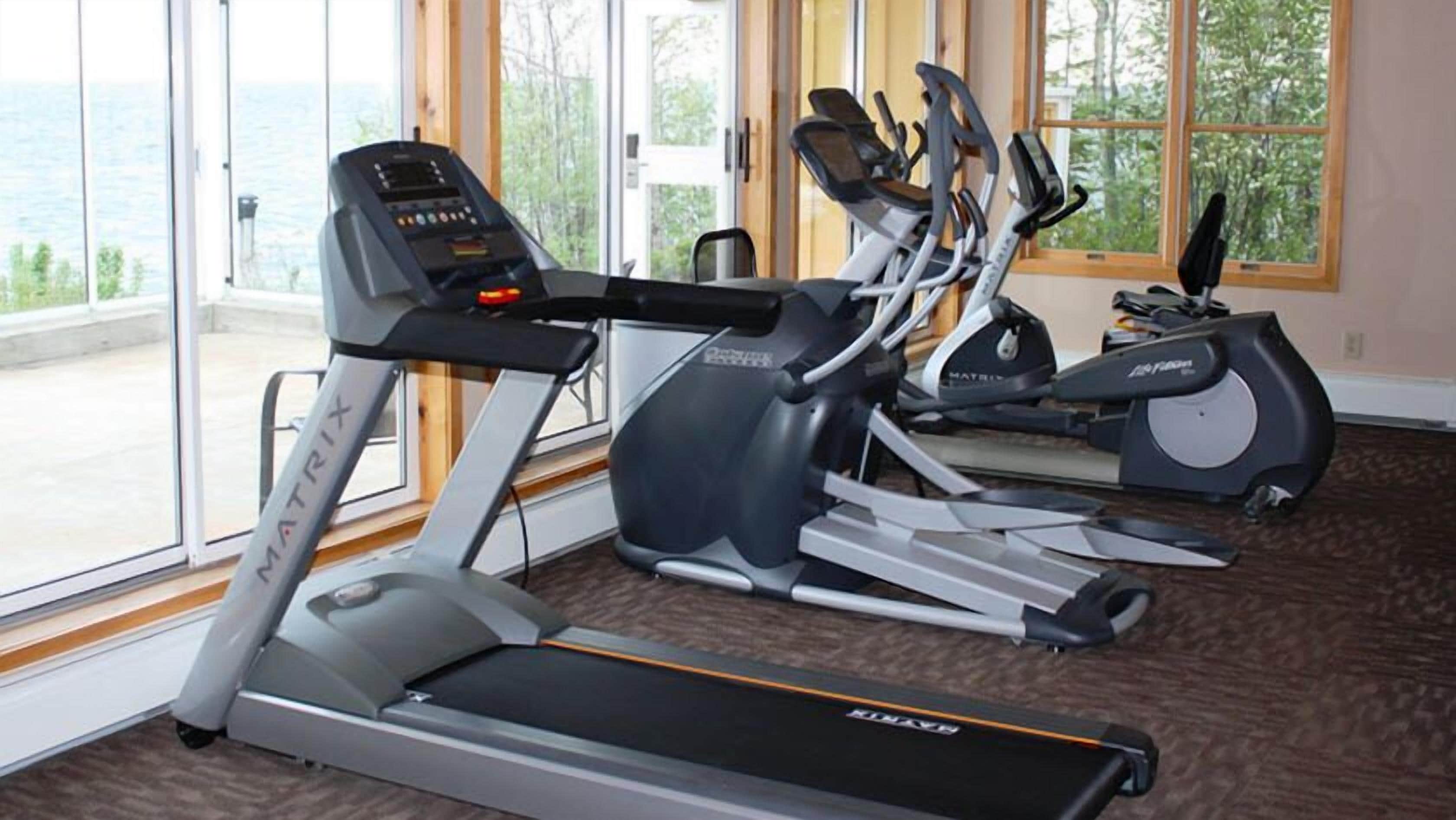A gym with treadmills, elliptical machines, and stationary bikes.