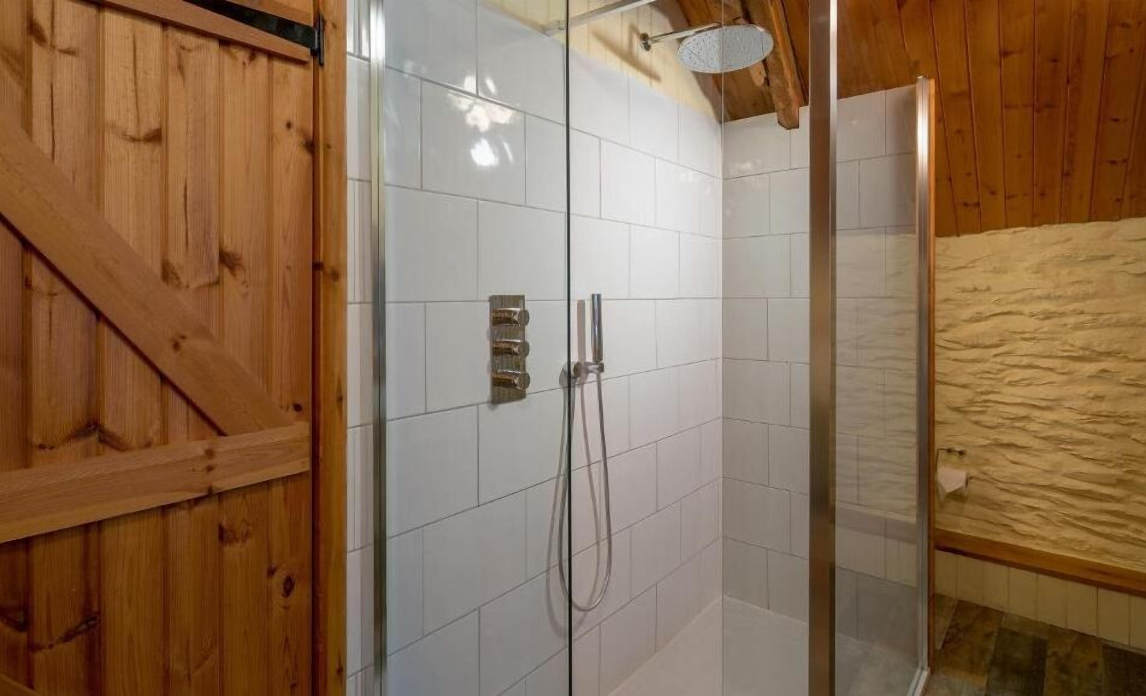 A wooden interior with a glass shower enclosure and a wooden ceiling.