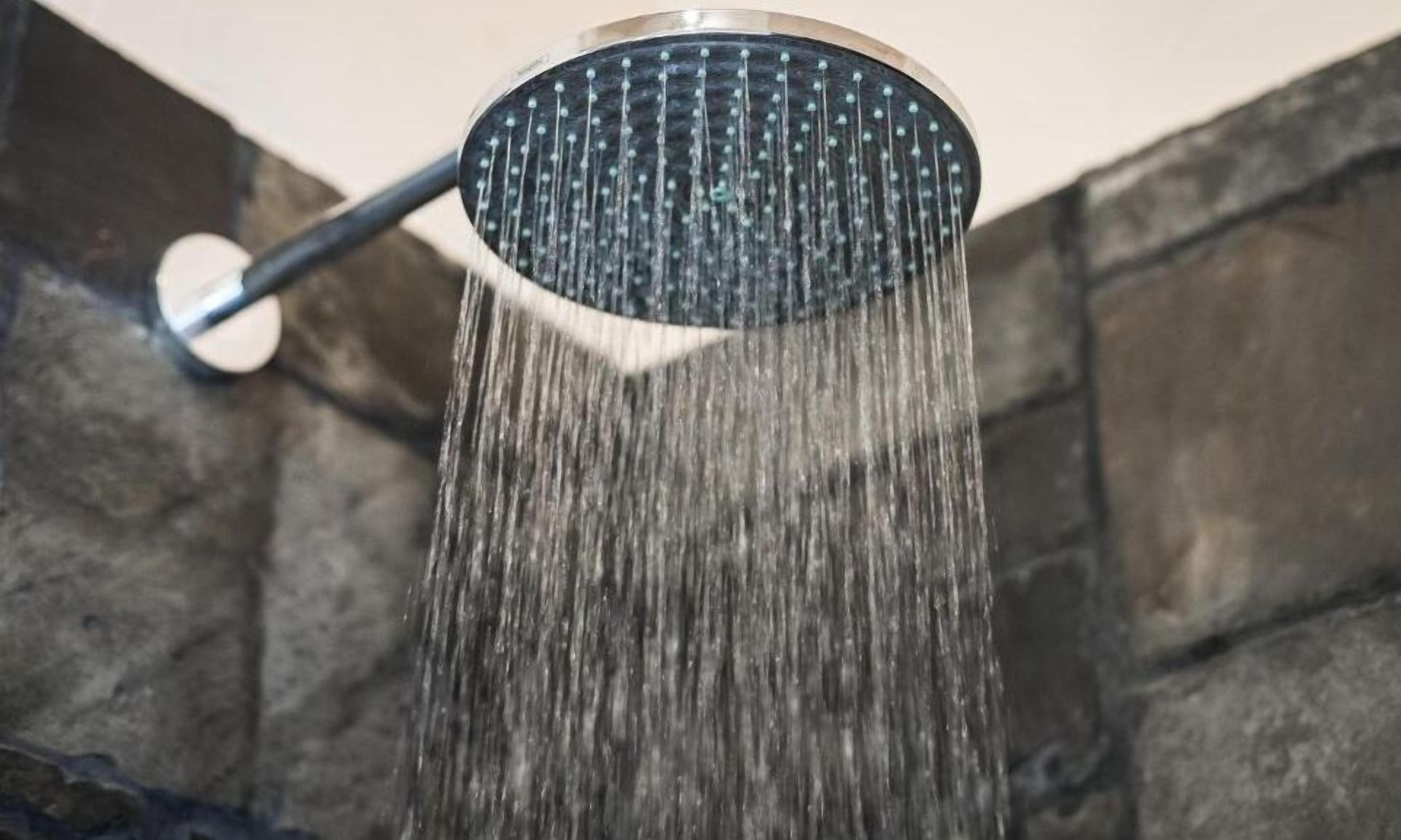 Un cabezal de ducha con agua fluyendo.
