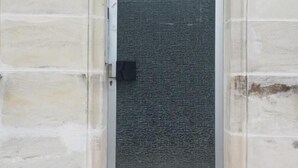 A building entrance with a numbered door, a textured door screen, and a tiled step. - Ferienwohnung Raab (Nuremberg)