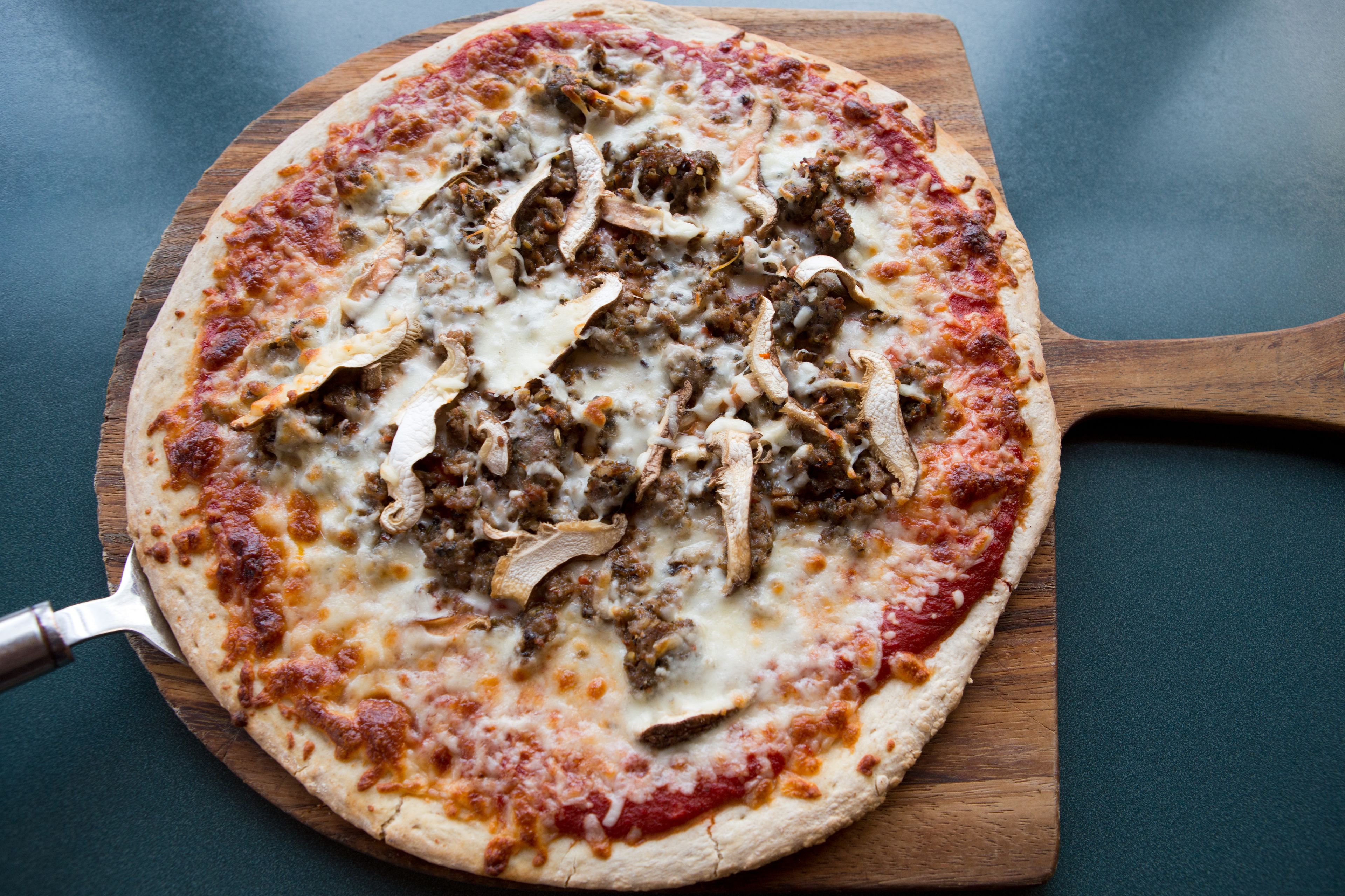 A pizza on a wooden board.
