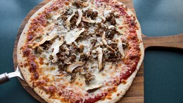 A pizza on a wooden board.