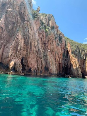 A coastal cliff with clear turquoise water. - Corsica Paradise (Calcatoggio)