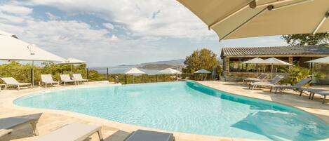 Een seizoensgebonden buitenzwembad, parasols voor strand/zwembad