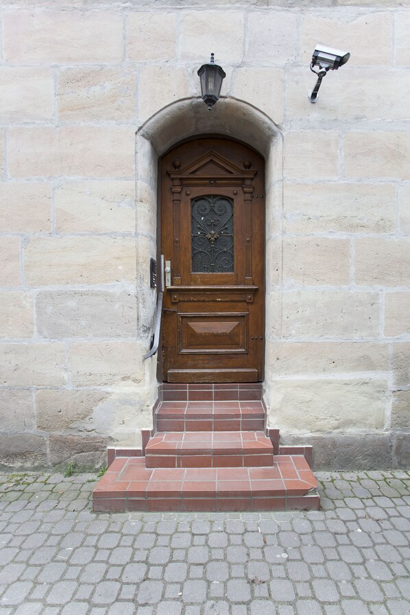 Traditional entrance with stone wall and interlocking brick ground.