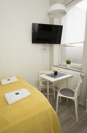 Relax in a cozy space with a comfortable bed, flat-screen TV, and a view of the outside.