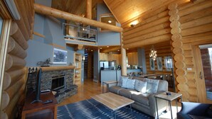 A spacious log cabin interior with a living room, dining area, and kitchen. - Temperance Landing on Lake Superior (Schroeder)