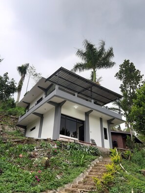 A modern two-story house with a flat roof and large windows. - Cahaya Bukit Cemara (Batu)