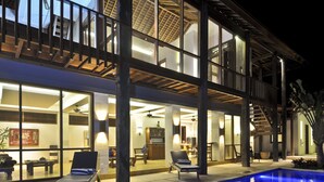 Un hôtel moderne doté d’une piscine, de grandes fenêtres et d’un espace repas.