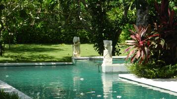 Alberca al aire libre, sombrillas en la alberca y camastros