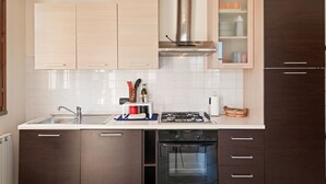 A modern kitchen with a built-in gas stove, stainless steel range hood, and a dishwasher. - Lucca - Via Viaccia 155 (Lucca)