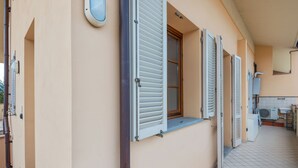 A corridor with a tiled floor, a window with shutters, and a radiator. - Lucca - Via Viaccia 155 (Lucca)