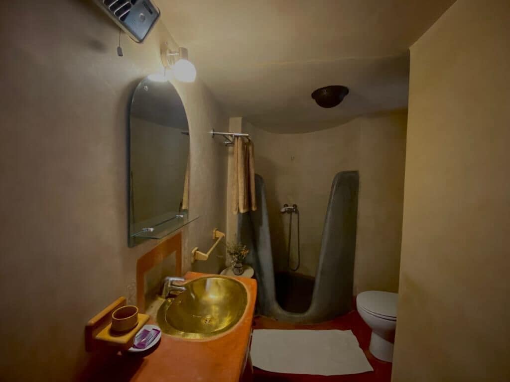 Un baño con un espejo grande, un lavabo, una ducha y un inodoro.